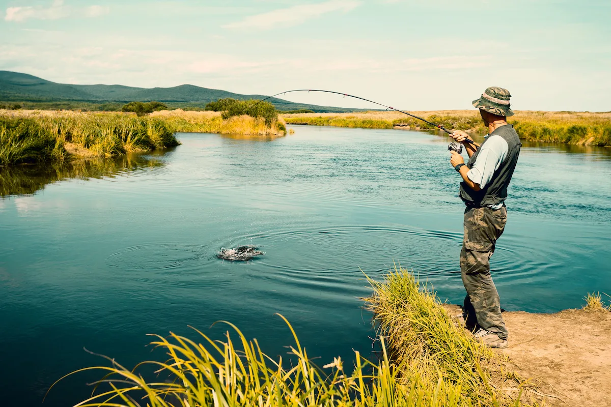 Man-catching-a-fish-with-a-fly-fishing-rod