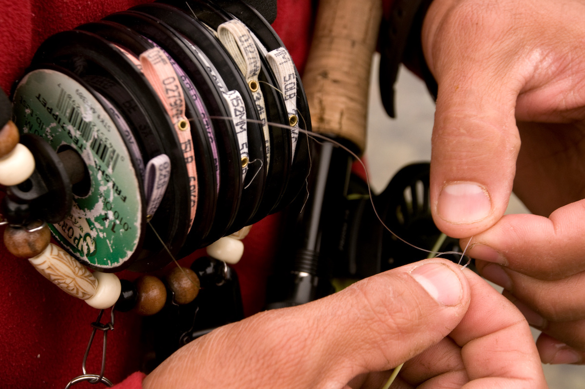 Mans-hands-tying-a-knot-with-fly-fishing-tippet