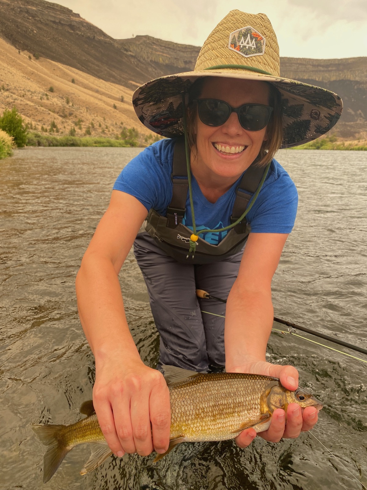 Woman-fly-fishing-holding-a-white-fish