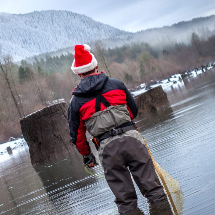 Fly-fisherman-wading-in-the-water-with-a-Santa-hat