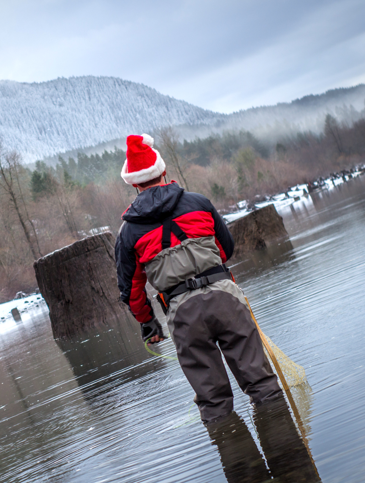 Fly-fisherman-wading-in-the-water-with-a-Santa-hat